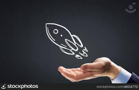 Drawn rocket. Human hand showing in palm drawn rocket sign