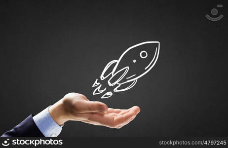 Drawn rocket. Human hand showing in palm drawn rocket sign