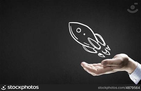 Drawn rocket. Human hand showing in palm drawn rocket sign