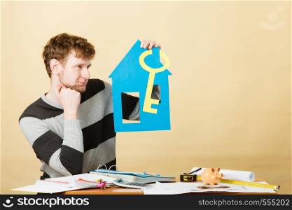 Dream about stabilization and family. Young man with paper house and big key. Dreaming boy full of plans ideas. New flat apartment.. Man with paper house and key.
