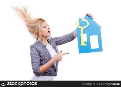 Dream about stabilization, plans for future. Blonde girl holding blue paper house model and yellow key cutout. New flat apartment. Isolated on white. Woman holding paper house model and key.