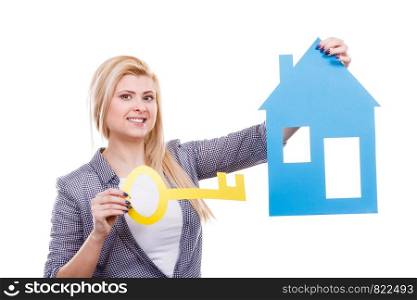 Dream about stabilization, plans for future. Blonde girl holding blue paper house model and yellow key cutout. New flat apartment. Isolated on white. Woman holding paper house model and key.
