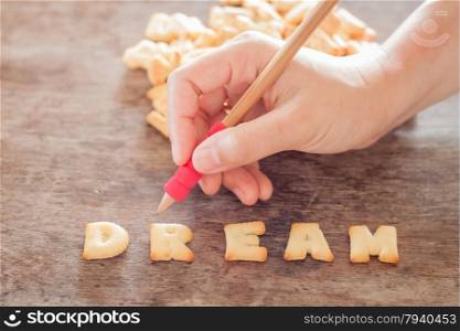 Dream alphabet biscuit on wooden table, stock photo