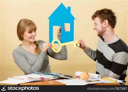 Dream and new plan for living. Young joyful smiling people thinking dreaming about their first house. Couple with big key to their future.. Happy couple dreaming about house.