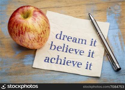 dream, believe, achieve it concept - handwriting on a napkin with a fresh apple