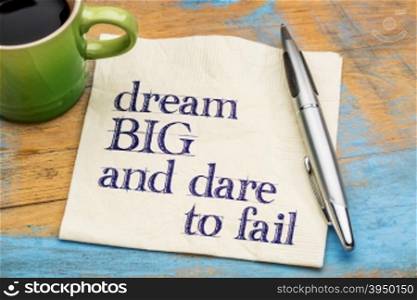 Dream big and dare to fail - motivational phrase on a napkin with a cup of coffee