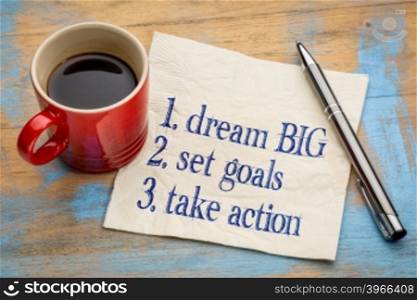 dream big, set goals, take action - inspirational handwriting on a napkin with a cup of coffee