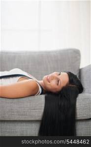 Dreaming long hair young woman laying on couch