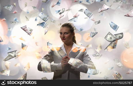 Dreaming to become rich. Young businesswoman standing in the rain of money banknotes