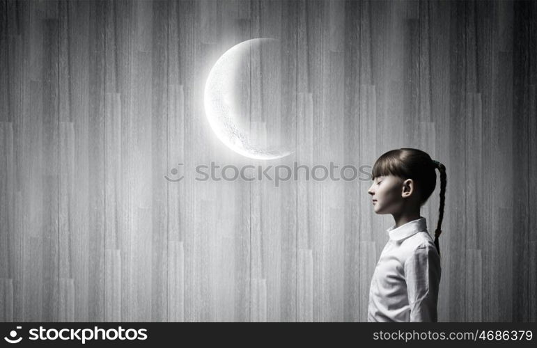 Dreaming with closed eyes. Side view of cute girl and moon above her head