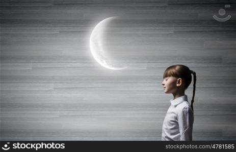 Dreaming with closed eyes. Side view of cute girl and moon above her head