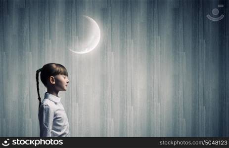 Dreaming with closed eyes. Side view of cute girl and moon above her head