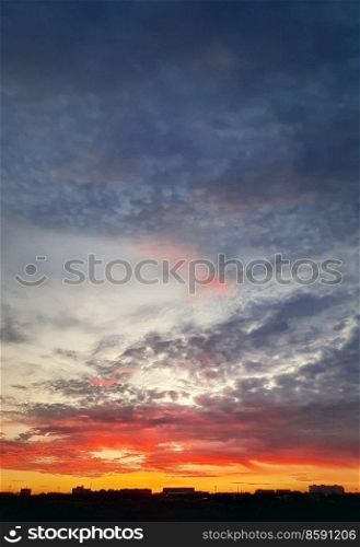 Dreamlike colorful sunset over the city horizon, vertical celestial  background