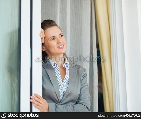 Dreamy business woman near window looking into distance