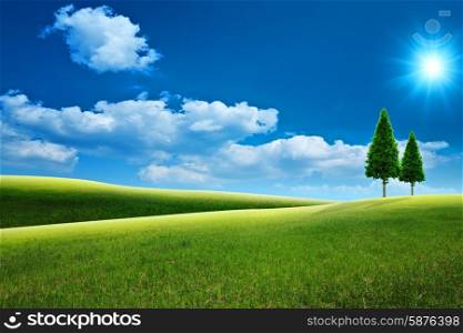 Dreamy natural landscape with green hills under blue skies and couple of woods