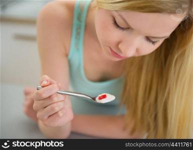 Dreamy teenager girl eating yogurt