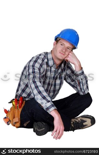 Dreamy tradesman sitting cross-legged