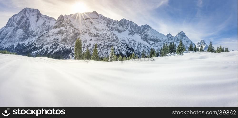 Dreamy winter panorama with the Austrian Alps mountains, the fir forests and a thick layer of snow over a valley, on a sunny day of December.