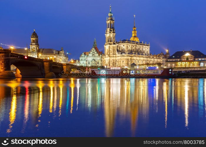 Dresden Cathedral of the Holy Trinity aka Hofkirche Kathedrale Sanctissima Trinitatis and Augustus Bridge with reflections in the river Elbe at night in Dresden, Saxony, Germany