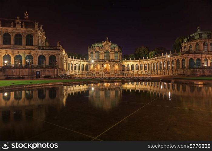 Dresden Zwinger palace panorama with illumination at night and water reflection, Germany&#xA;