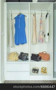 Dresses, bags and shoes in white wardrobe