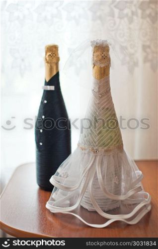 Dresses of the groom and the bride on bottles with champagne.. Clothes on a bottle.