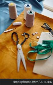 Dressmaking tools on the table, top view, nobody. Professional sewing, handmade tailoring business, handicraft hobby, fabric textile on background. Seamstress or dressmaker accessory.. Dressmaking tools on the table, top view, nobody