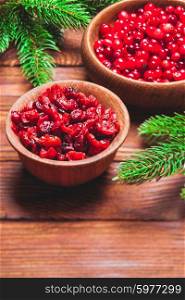 Dried and fresh cranberries in a wooden bowls. Dried and fresh cranberries