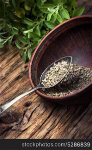 dried and fresh oregano herb on wooden background. spice oregano herb