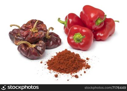 Dried and fresh red bell peppers and a heap of powder isolated on white background