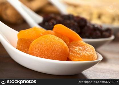 Dried apricots on ceramic spoon (Selective Focus, Focus on the apricot in the front)