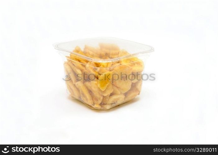 Dried Banana Chips. Sliced and dried bananas in a clear airtight plastic container on a white background