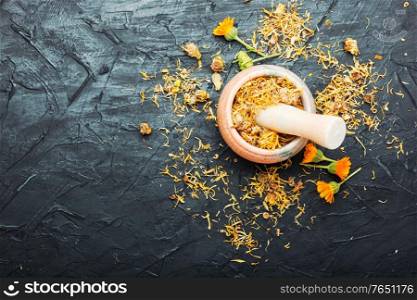 Dried calendula in mortar and pestle.Herbal medicine.Calendula or marigold dry.Copy space. Dried calendula flower