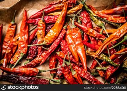 Dried chili peppers on paper. Macro background. High quality photo. Dried chili peppers on paper.