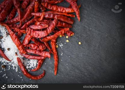 dried chilli with salt herbs and spices on dark background