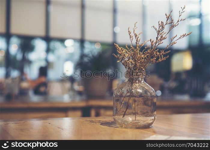 Dried flowers are placed in a vase on a luxury dinner table.