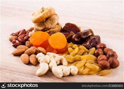 Dried fruits and nuts heaps on wooden table