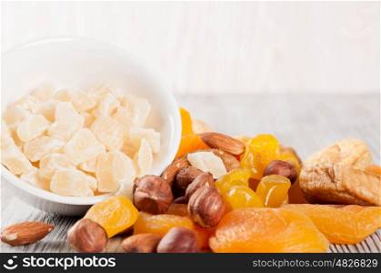 Dried fruits and nuts on a wooden background