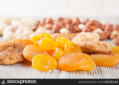 Dried fruits and nuts on a wooden background. Candied fruits, lemon, apricot, fig and nuts.