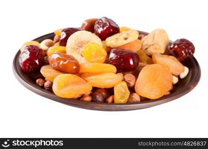 Dried fruits isolated on a white background. Dates, lemon, apricots, figs and nuts in a clay plate.