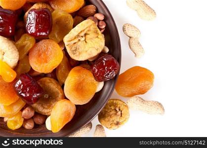 Dried fruits on a white background. Dates, lemon, apricots, figs and nuts in a clay plate.