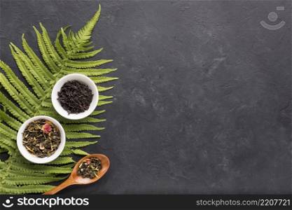 dried herb tea white ceramic bowl with fern leaves black background