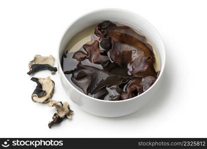 Dried jews ear mushrooms soaking in water in a bowl close up isolated on white background