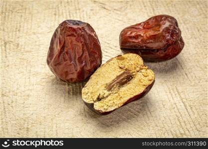 dried jujube fruits on textured bark paper