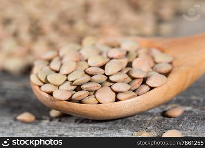 Dried lentils placed in a wooden spoon