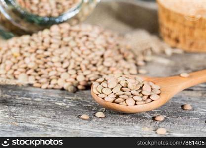 Dried lentils placed in a wooden spoon