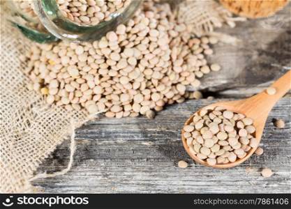 Dried lentils placed in a wooden spoon