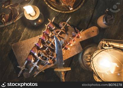 Dried meat on wooden table. Vintage style. Fire light