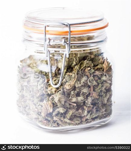 Dried mint for tea in a glass jar isolated