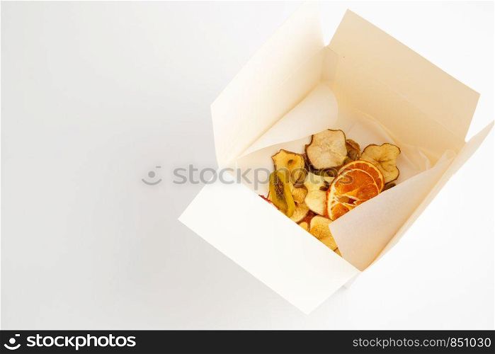 dried oranges,bananas and apples in white box on white background
